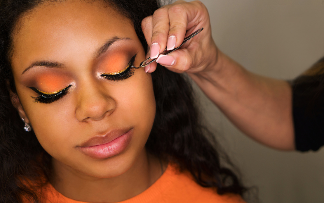 Makeup artist applies makeup on face of girl